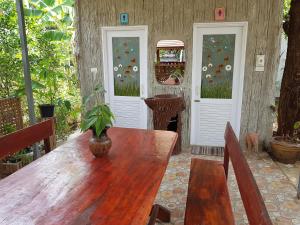 武里南Greenhouse resort的木桌,上面有盆栽植物