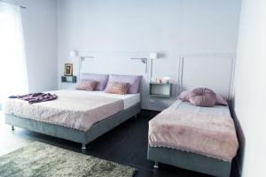 斯培西亚5 Terre Inn Affittacamere的一间卧室配有两张带枕头的床。