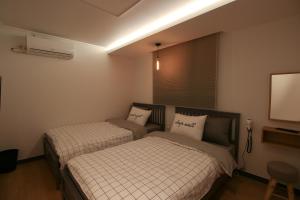 首尔Heima Guesthouse Hongdae的一间带两张床和电视的卧室