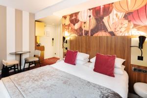 里昂里昂中心共和广场美居酒店的酒店客房配有一张带红色枕头的大床