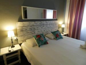 托莱多托莱多绿洲背包客旅馆的一间卧室配有一张带两盏灯和镜子的床