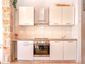 伊万多拉克Apartment Spila的厨房配有白色橱柜和炉灶。
