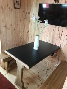 基尔肯尼Cosy Countryside Log Cabin的一张黑色桌子,上面有白色花瓶