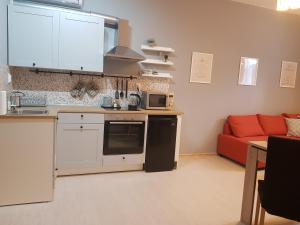 RadomirRadomir Downtown Apartments的客厅里的厨房配有红色沙发