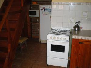 埃博森卡瓦尼亚斯图仁旅馆的厨房配有白色炉灶和冰箱。