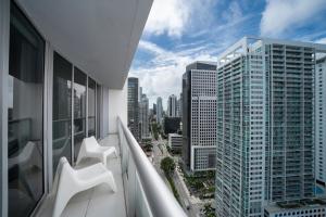 迈阿密Icon Residences by SS Vacation Rentals的一个带两把白色椅子的阳台,并享有城市美景。