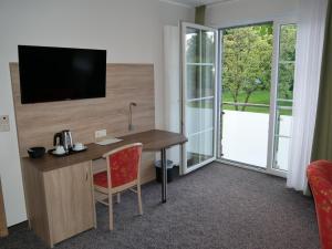 Diekholzen卡斯托夫琼斯酒店的客房设有书桌、电视和窗户。