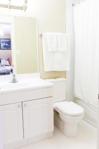 Cold LakeLakeshore Inn的白色的浴室设有卫生间、水槽和镜子