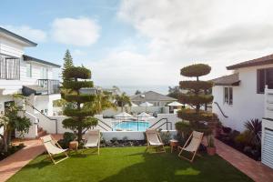 拉古纳海滩Hotel Joaquin - Adults Only的一个带椅子的庭院和一个带游泳池的庭院