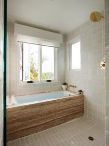 拉古纳海滩Hotel Joaquin - Adults Only的带浴缸的浴室和窗户
