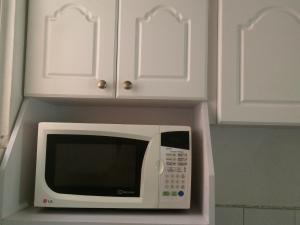 圣萨尔瓦多Room 4 rent的厨房设有微波炉,配有白色橱柜