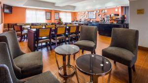 俄克拉何马城Best Western Plus Barsana Hotel & Suites的一间带桌椅的餐厅和一间酒吧