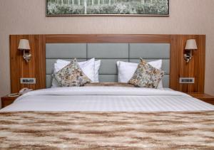 迪拜Jacob's Garden Hotel的一间卧室配有一张带枕头的大床
