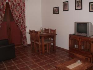 La Virgen de la Vega玛丽亚别墅的客厅配有桌子和电视