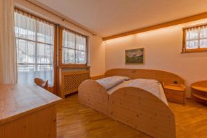 圣坎迪朵LERCHER Anna Villa Lercher的一间卧室设有一张木床和一个大窗户。