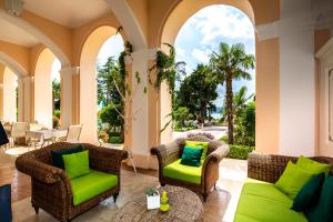 茨里克韦尼察克瓦内尔宫酒店的一个带柳条椅和绿色靠垫的门廊