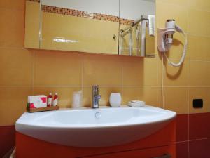 贝内文托B&B Domus Traiani Benevento的浴室设有白色水槽和镜子