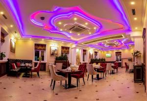 特维尔Golden Plaza Hotel的餐厅设有桌椅和紫色天花板