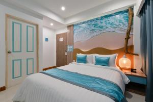 乔木提恩海滩T2 Jomtien Pattaya的卧室配有一张大床,墙上挂有绘画作品