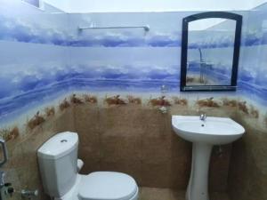 安帕赖Quench Inn的一间带卫生间、水槽和镜子的浴室