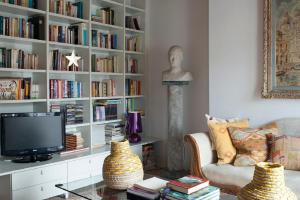 威尼斯Terrazza Momon的客厅设有书架,书架上摆放着书籍