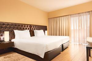 塞辛布拉道斯孜伯劳斯酒店的一间卧室设有一张大床和一个大窗户
