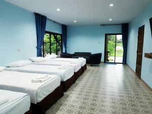 Ban Wang TakhraiSophia Resort的蓝色墙壁的房间的一排床位