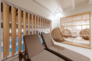 摩拉瓦托普利采阿扎酒店 - 泰尔梅3000 - 萨瓦酒店及度假村 的一间带两把椅子的房间和一个游泳池
