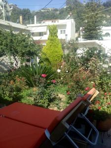 ChoudetsiArtemisia Traditional Home的鲜花盛开的花园前的红色长凳