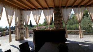卡瓦伊翁韦罗内塞Casa Quarole Garda-Meer的庭院中设有白色窗帘和沙发的凉亭