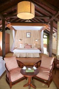 奈瓦沙东非大裂谷旅舍及高尔夫度假酒店的卧室配有一张床和一张桌子及椅子