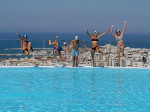 维耶斯泰Villa Coppitella, rooms & apartments的一群人跳进游泳池的水中
