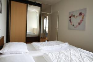 布雷斯肯斯Hello Zeeland - Appartement Port Scaldis 13-111的一间卧室配有两张白色的床和镜子