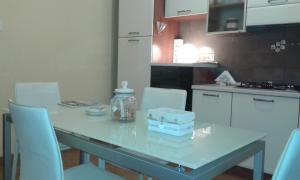 特尔尼Belvedere Valenza的厨房配有带白色椅子的桌子、桌子和桌子。