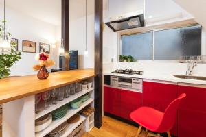 东京Suiren Residential Suite Tokyo的一间厨房,配有红色橱柜和红色椅子