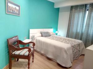雷凯蒂奥Apartamento centrico en Lekeitio, playa y puerto的一间卧室配有一张大床和一把椅子
