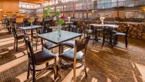 锡代利亚国展贝斯特韦斯特酒店的餐厅设有桌椅,并种有鲜花