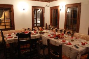 西洛卡卢卡Къща за гости Гайтана的一间设有长桌及白色桌布的用餐室