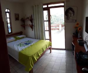 伦索伊斯casa de Luciana - Lençóis的一间卧室设有一张床和一个滑动玻璃门