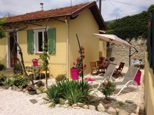拉特里尼泰Le 43的房屋设有带椅子和遮阳伞的庭院