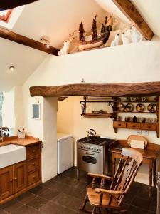 普尔赫利The Piggery - North Wales Retreat的厨房配有炉灶、桌子和椅子