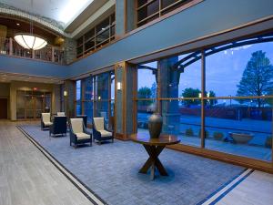 埃文斯维尔Bally's Evansville Casino & Hotel的大堂设有桌椅和窗户。
