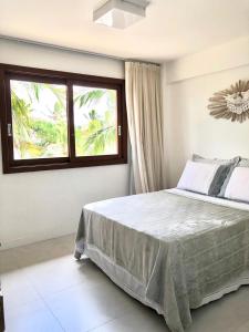 普拉亚多Residencial Enseada Praia do Forte Apto 130的一间卧室设有一张大床和一个窗户。