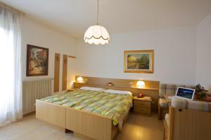卡拉诺艾尔伯格贝拉利雅酒店的一间卧室配有一张大床和一个吊灯。