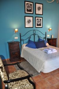 钦琼艾尔阿布鲁葵可卡萨乡村酒店的一间卧室配有一张床、一把椅子和蓝色的墙壁