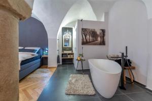 帕绍Passau42的一间带浴缸的浴室和一张位于客房内的床