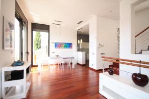 莱斯卡拉Villa Barbara的厨房以及铺有木地板的用餐室,配有白色的墙壁。