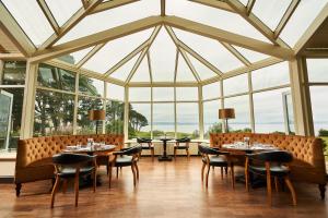 奈恩克瑞拉高尔夫景酒店&SPA的用餐室设有桌椅和窗户。