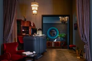 布达佩斯Hotel Collect - Adults Only的客厅配有蓝色冰箱和红色椅子