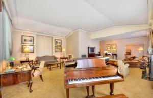 悉尼斯坦福圆码头酒店的客厅配有钢琴和沙发